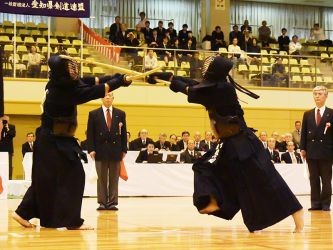 決勝 恩田浩司(東京)コメ─ド 石田利也(東京)
ともに豪快なメン技を武器に決勝に駒を進めてきた両者。序盤はともにメンを警戒しているのか、相手に充分に打たせない攻防となる。が、まだ前半のうちに恩田のメンを石田がドウにさばいて一本を先取し、試合が動き出した。すると恩田は1分ほどで石田の手元が上がるところにコテに跳び込み追いつく。
その後は石田のコテ、恩田のメン、石田のメンと恩田の出ゴテの打ち合いなど惜しい技が見られたが一本にはならず、延長に入る。そして延長の初太刀、恩田は機を探り、相手が手元を上げかけて下げる瞬間をとらえ、真っ向からメンに跳び込んだ。優勝を決めた一打も、この日恩田が終始見せていた捨て切ったメンだった。 真っ向からメンに跳び込んだ