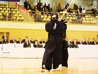 1回戦 石田利也(東京)メ─ 浦和人(兵庫)
相メンとなり石田(写真・背中が浦)のメンが有効打となる。先制を許した浦だったが、石田のコテが外れたところにメンなど、あと一歩で旗が上がりそうな場面を何度か作った。石田が迫力ある攻めで僅差で勝利を手にした印象の一戦だった。 相メンとなり石田(写真・背中が浦)のメンが有効打となる。
